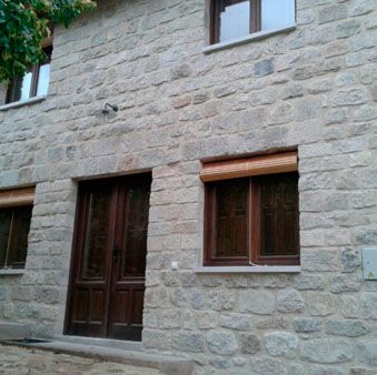 Construcciones y Reformas Teo & Dani casa de piedra con ventanas y puerta de madera